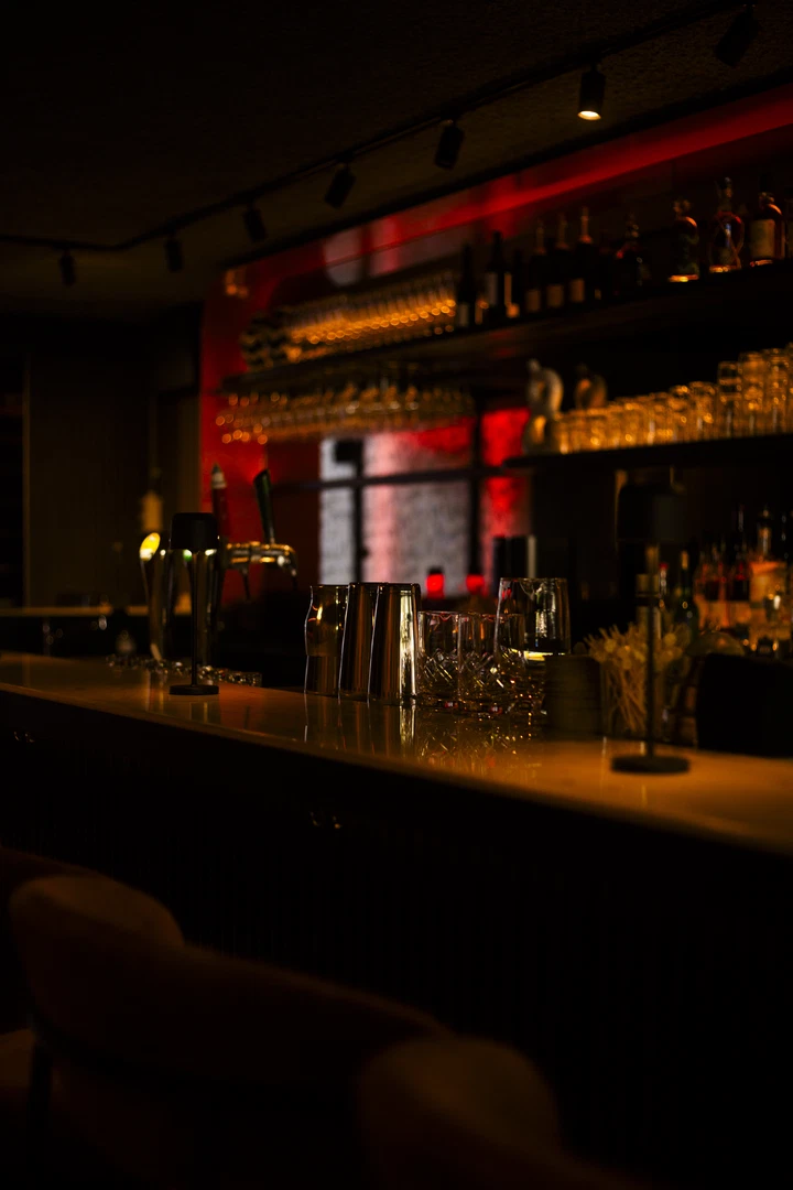 Bar van Alba met rood licht en flessenrekken