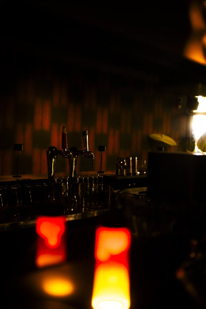 Glazen en flessen achter de bar in warm avondlicht